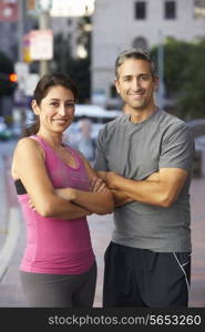 Portrait Of Male And Female Runners On Urban Street