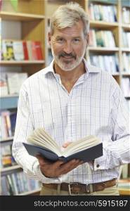 Portrait Of Male Customer Reading Book In Bookstore