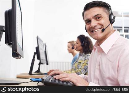 Portrait Of Male Customer Services Agent In Call Centre