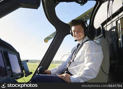 Portrait Of Male Helicopter Pilot In Cockpit Before Flight