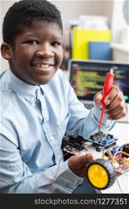 Portrait Of Male High School Pupil Building Robot Car In Science Lesson