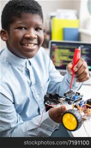 Portrait Of Male High School Pupil Building Robot Car In Science Lesson