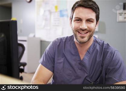 Portrait Of Male Nurse Working At Nurses Station