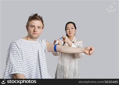 Portrait of male patient with doctor preparing him for a blood test