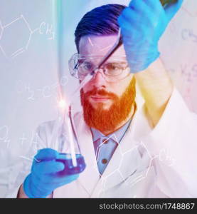 Portrait Of  Male Researcher In The Laboratory, holding a dropper and a test tube