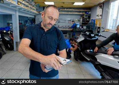 portrait of male worker in motorbike store