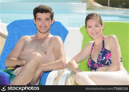 Portrait of man and lady sat on sun loungers
