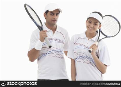 Portrait of man and woman holding rackets isolated over white background