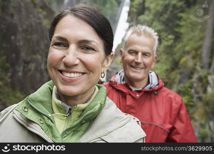 Portrait of man and woman smiling, waterfall in background