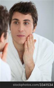 Portrait of man applying moisturizer on his face