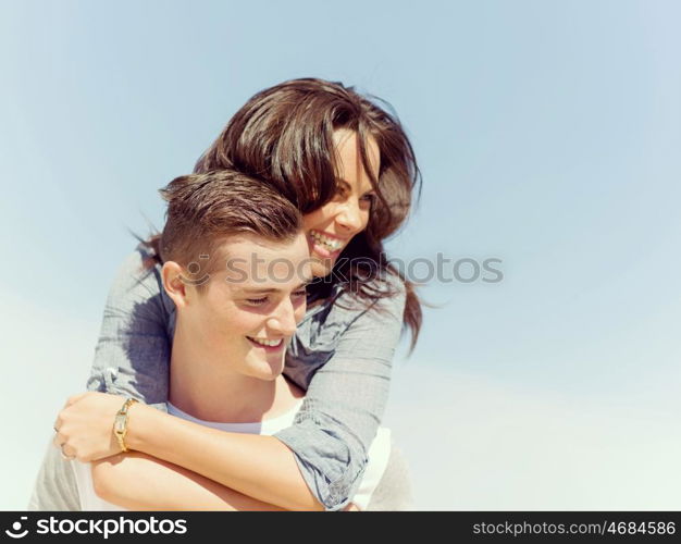 Portrait of man carrying girlfriend on his back. Portrait of man carrying girlfriend on his back on the beach