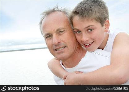 Portrait of man carrying young boy on his back