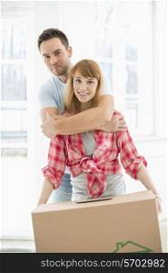 Portrait of man embracing woman in new house