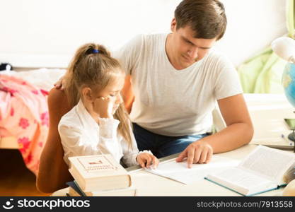 Portrait of man explaining daughter how to do homework