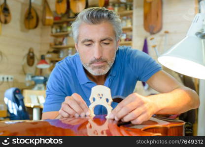 portrait of man fitting the viola bridge