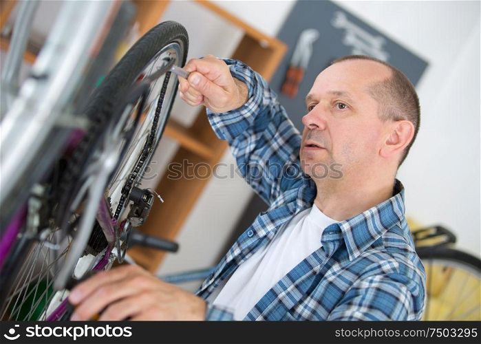 portrait of man fixing a bike