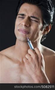 Portrait of man giving himself botox injection