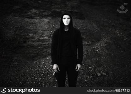 Portrait of man in black hoodie wearing white anonymous mask.. Portrait of man in black hoodie wearing white anonymous mask