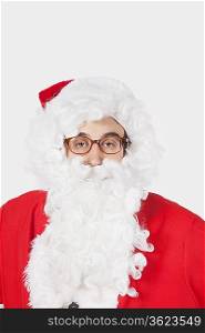 Portrait of man in Santa costume against gray background
