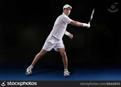Portrait of man in sportswear playing tennis at court