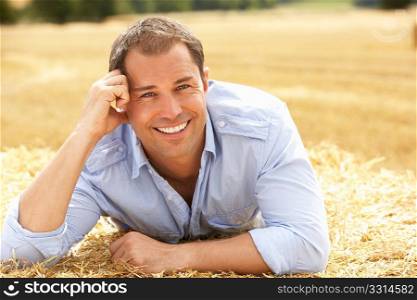 Portrait Of Man Laying In Summer Harvested Field