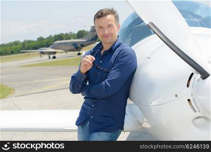Portrait of man leaning against aircraft