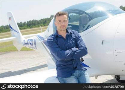Portrait of man leaning on aircraft