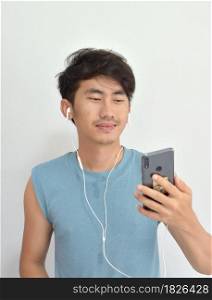 Portrait of man listening music with his smartphone over white background