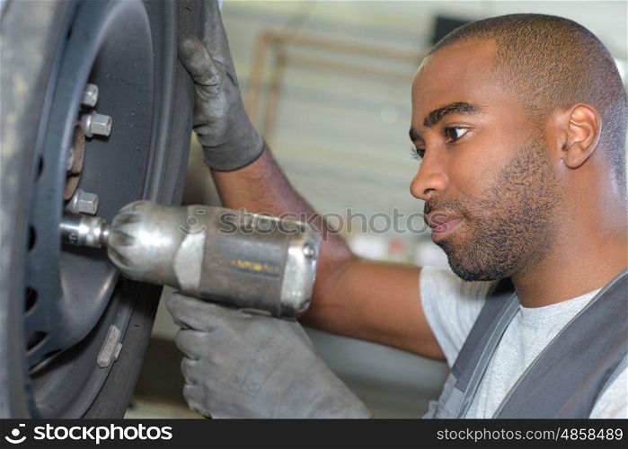 portrait of man mechanic changing tyre