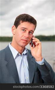 Portrait of man near pond, which speaks on cell phone