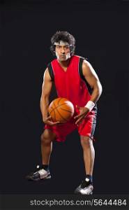 Portrait of man playing basket ball over white background