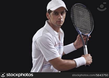 Portrait of man playing tennis isolated over black background