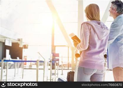Portrait of man pushing baggage cart for check in with her daughter at airport