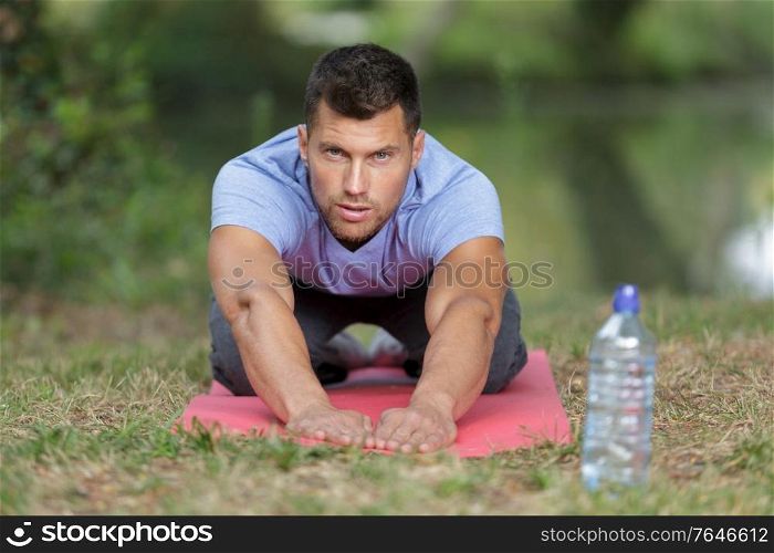 Portrait of man reaching forward on exercise mat