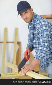 portrait of man sawing wood
