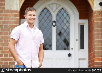 Portrait Of Man Standing Outside Front Door Of Home