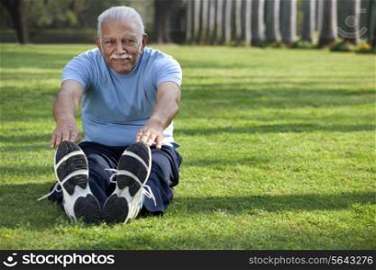 Portrait of man stretching in park