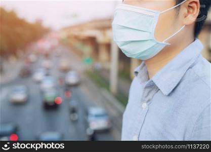 Portrait of man wearing facial hygienic mask nose outdoors. Ecology, air pollution car, Environmental and virus protection concept flu health against toxic dust covered the city of a health effect.