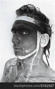 Portrait of man with black theatrical makeup on white background