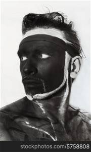Portrait of man with black theatrical makeup on white background