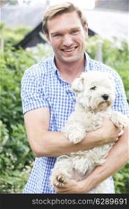 Portrait Of Man With Pet Dog In Garden