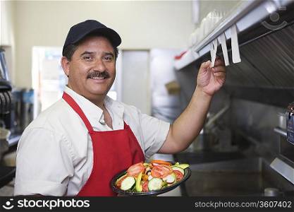 Portrait of man working in restaurant kitchen
