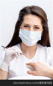 Portrait of manicure master with protective mask working with female customer in beauty salon. Portrait of manicure master with protective mask