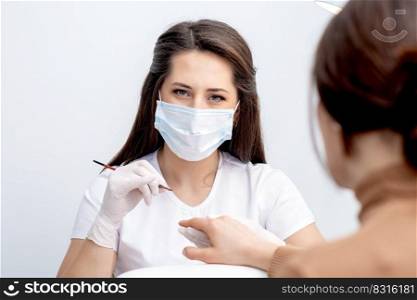 Portrait of manicure master with protective mask working with female customer in beauty salon. Portrait of manicure master with protective mask