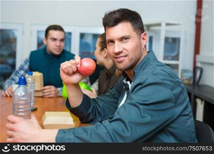 portrait of manual worker eating apple on lunch break