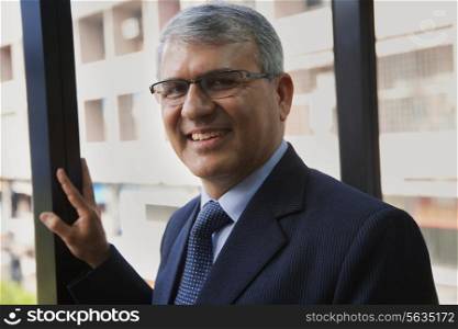 Portrait of mature businessman smiling at workplace