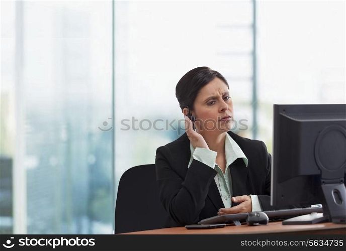 Portrait of mature businesswoman on call while looking at computer