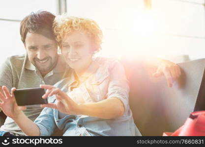 Portrait of mature couple taking selfie while waiting for boarding in airport