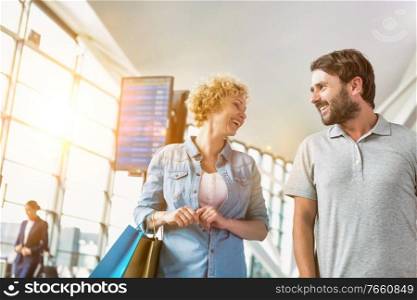 Portrait of mature couple walking while talking in airport