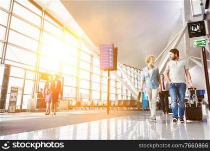 Portrait of mature couple walking while talking in airport